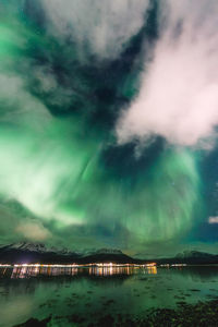 Dramatic northern lights over snowcapped mountains at the sea