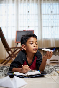 Full length of boy sitting on table