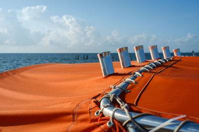 Close-up of deck chairs on beach against sky
