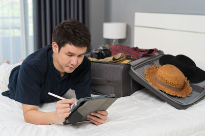 Side view of man using laptop while sitting on table