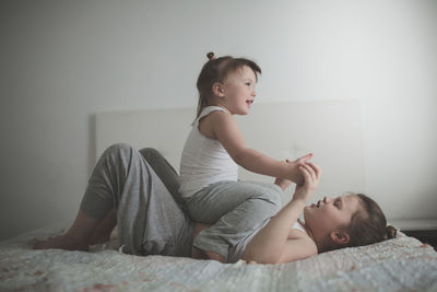 Sister girls play playfully on the bed, emotions. they swear and joke. concept childhood 