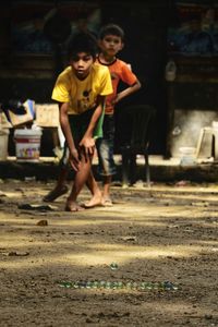 Full length of siblings playing on field