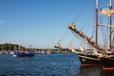 Sailboats sailing in sea against clear sky