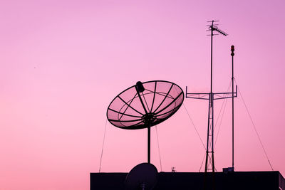 Low angle view of silhouette antenna against clear sky during sunset