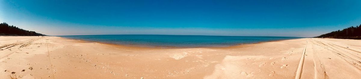 Panoramic view of beach against clear blue sky