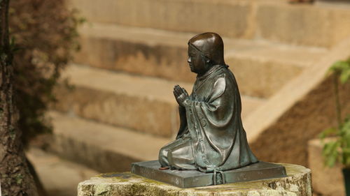 Statue of buddha against wall