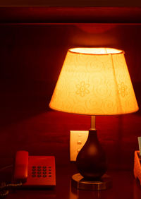 Close-up of illuminated lamp on table at home