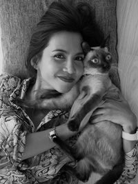 Portrait of woman with cat on blanket