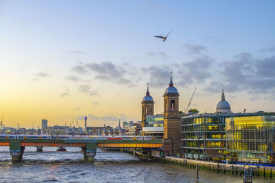 View of buildings at waterfront against cloudy sky