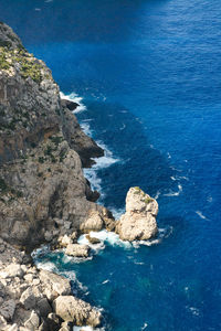 High angle view of rocks on sea shore