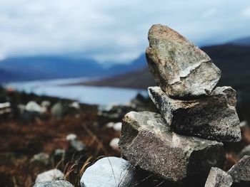 Close-up of stones on rock against sky