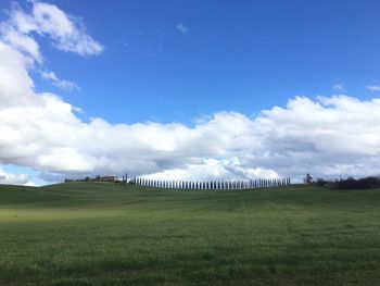 Scenic view of grassy field against cloudy sky