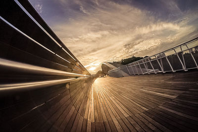 Road by bridge against sky during sunset