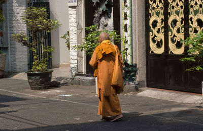 Rear view of woman standing against building