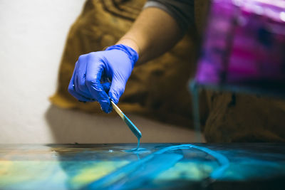 Female resin artist using simple tools to mix resin tint