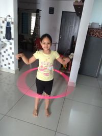 Portrait of girl standing on floor at home