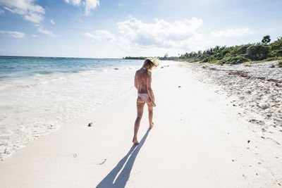 Full length of woman on beach against sky