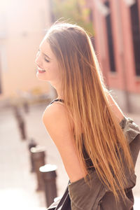 Beautiful young woman standing on footpath