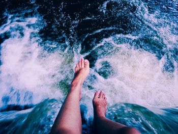 Low section of woman feet in swimming pool