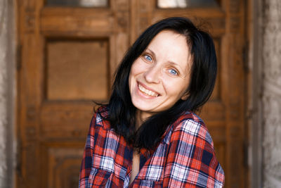 Close-up face of pretty woman with blue eyes, natural dark hair, no makeup