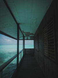 Corridor of building by sea against sky