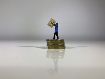 Man with toy standing on table against white background