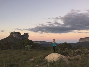 Full length of woman doing yoga on rock against sky during sunset at chapada diamantina national park