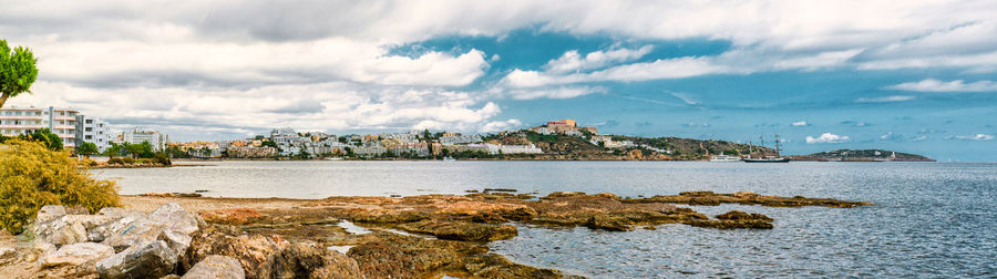 Panoramic view of sea and cityscape against sky