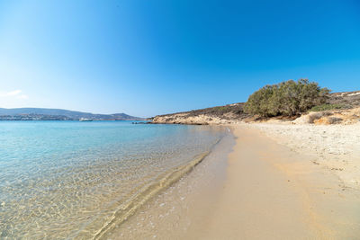 Scenic view of beach against clear blue sky