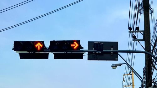 Low angle view of road signal against sky