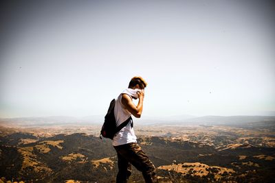 Man standing on landscape against sky