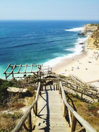 Stairs leading to beach with calm blue sea