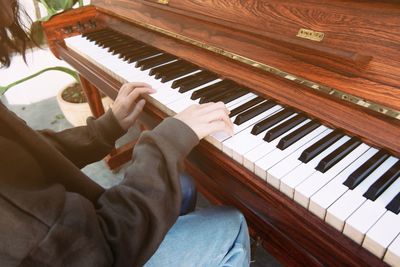 Midsection of woman playing piano