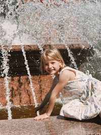 Portrait of young woman sitting in water