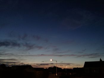 Low angle view of silhouette houses against sky at sunset