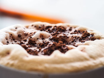 Close-up of chocolate cocoa powder on froth in coffee at cafe