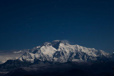 Scenic view of snowcapped mountains against sky at night