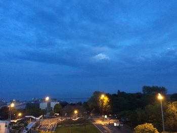 Illuminated street light against sky at night