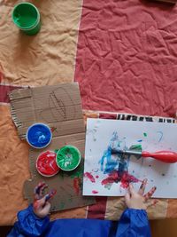 Cropped hand of child drawing at table