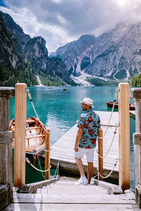 Person on deck chairs against mountains against sky