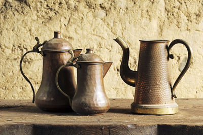 Close-up of vintage copper teapots on table