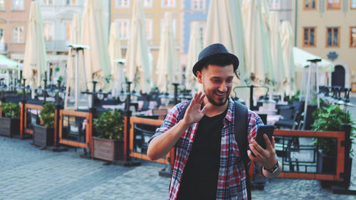 Young man smiling while standing in city