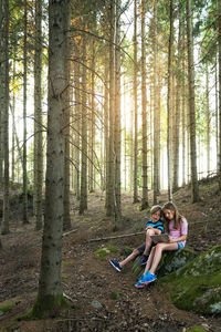 Boy and girl using digital tablet in forest