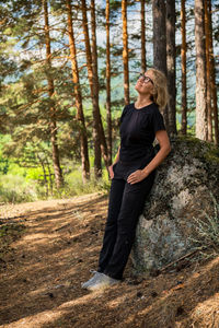 Portrait of young woman standing in forest