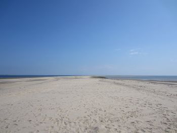 Scenic view of beach against clear blue sky