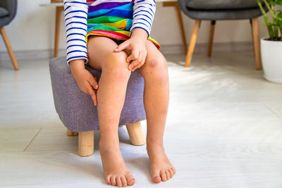 Low section of woman sitting on hardwood floor