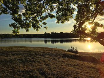 Scenic view of lake against sky at sunset