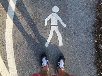 Low section of man standing on road