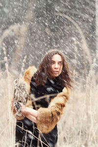 Young woman looking away standing outdoors during winter