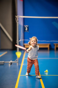 Rear view of girl playing with ball on court